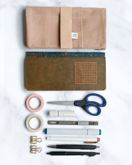 The Canvas Cover is a folding stationery pouch with a zipper compartment and internal sleeve for inserting 1 notebook cover. There are 3 additional pockets on the exterior for slim stationery tools such as pens or a ruler.
