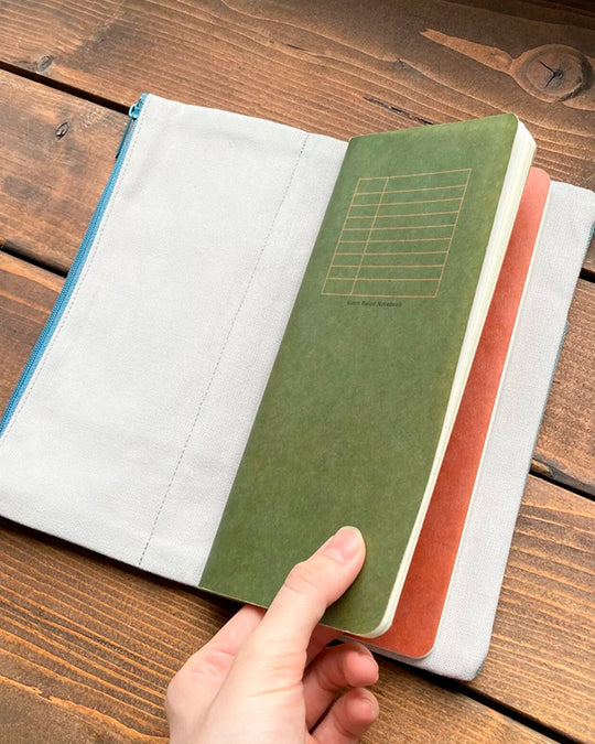 The Canvas Cover is a folding stationery pouch with a zipper compartment and internal sleeve for inserting 1 notebook cover. There are 3 additional pockets on the exterior for slim stationery tools such as pens or a ruler.