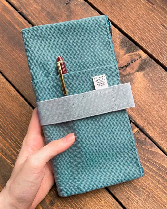 The Canvas Cover is a folding stationery pouch with a zipper compartment and internal sleeve for inserting 1 notebook cover. There are 3 additional pockets on the exterior for slim stationery tools such as pens or a ruler.