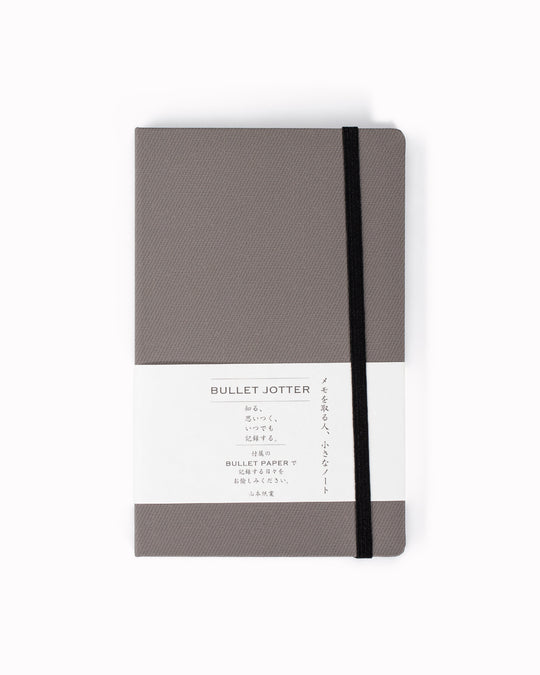 The Bullet Jotter by Yamamoto Paper is a modular note-taking system comprising an outer cover jacket with internal space to hold 2 bullet paper pads. 