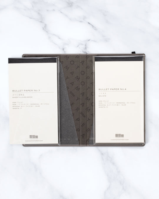 The Bullet Jotter by Yamamoto Paper is a modular note-taking system comprising an outer cover jacket with internal space to hold 2 bullet paper pads. 