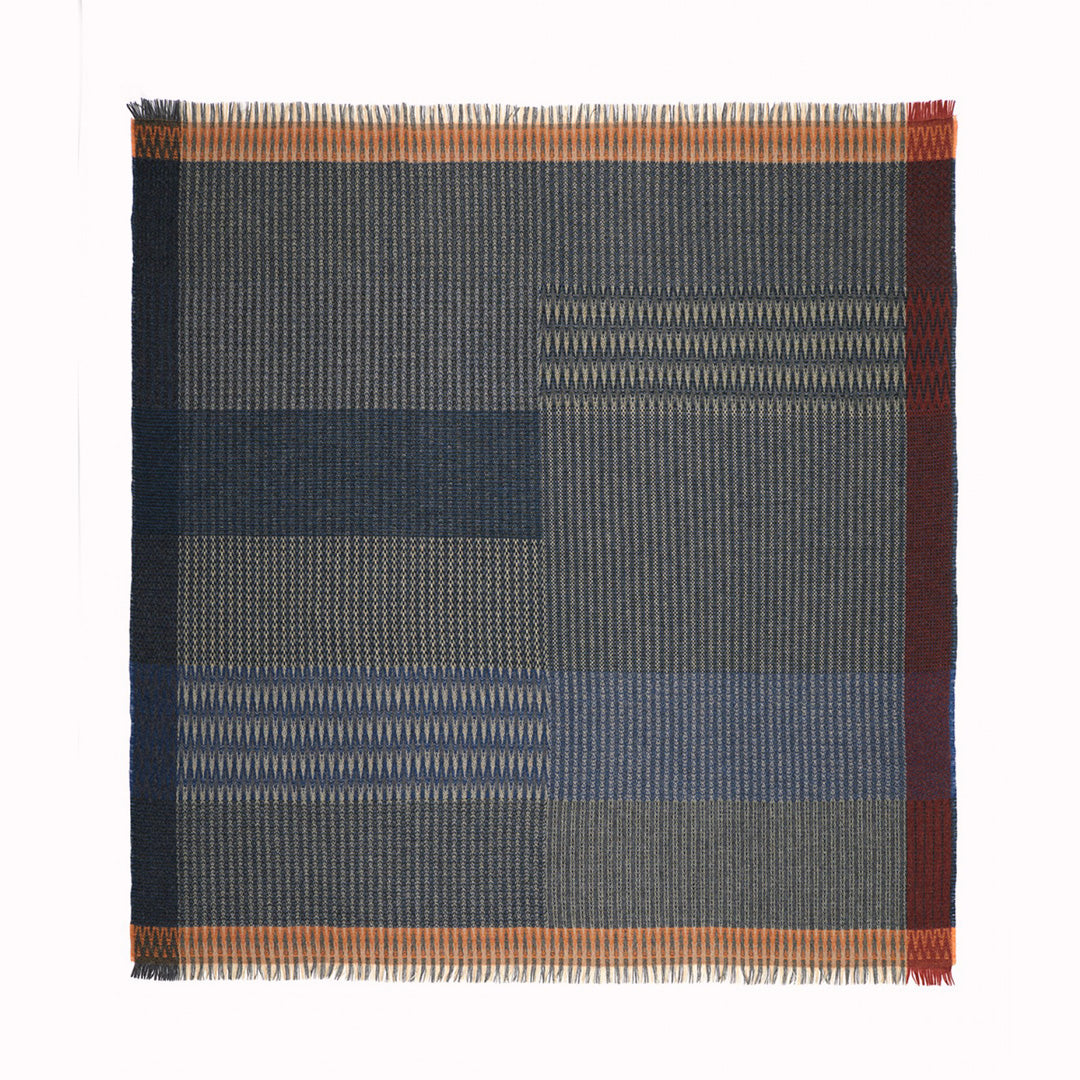 The Cairngorm Tweed Throw by Wallace and Sewell portrays the timeless beauty of Shetland wool craftsmanship. This particular throw features a harmonious blend of denim and rosemary green, set against the paler colours of the warp, creating a rich tapestry of structure and pattern.