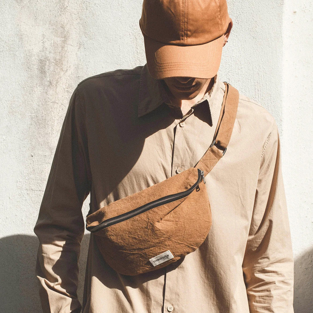 The Custine Belt Bag in classic Camel is a stylish and practical accessory crafted from upcycled denim. Designed by Rive Droite, a brand known for its commitment to sustainable fashion