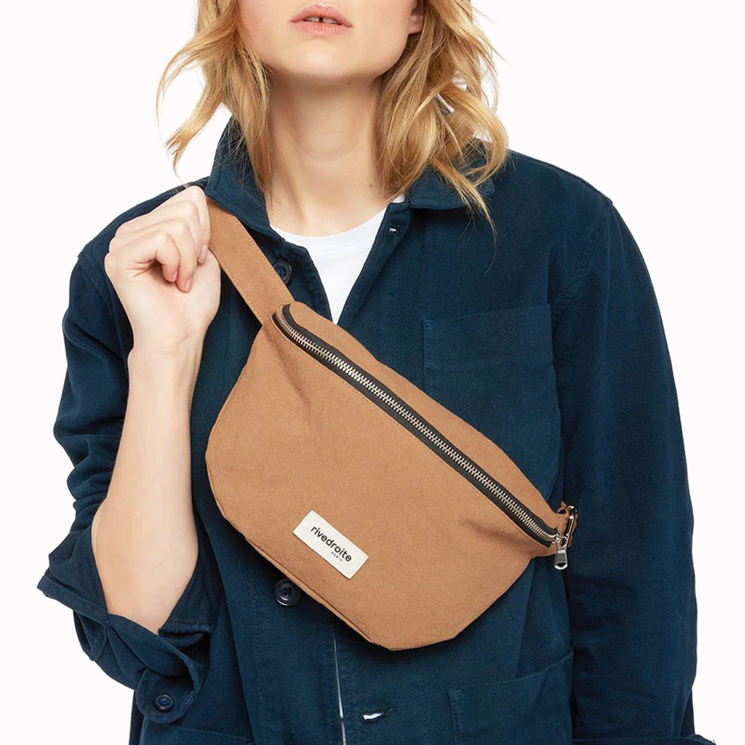 The Custine Belt Bag in classic Camel is a stylish and practical accessory crafted from upcycled denim. Designed by Rive Droite, a brand known for its commitment to sustainable fashion