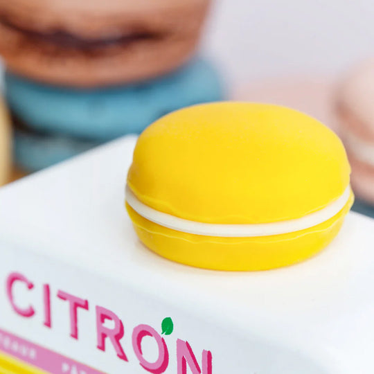 Roof detail for the Citron Macaron Van by Candylab. It is a toy vehicle inspired by French pastry shops. It has a bright yellow color and a macaron-shaped roof rack. The van is made of solid beech wood. It is a fun and stylish addition to any child's collection.
