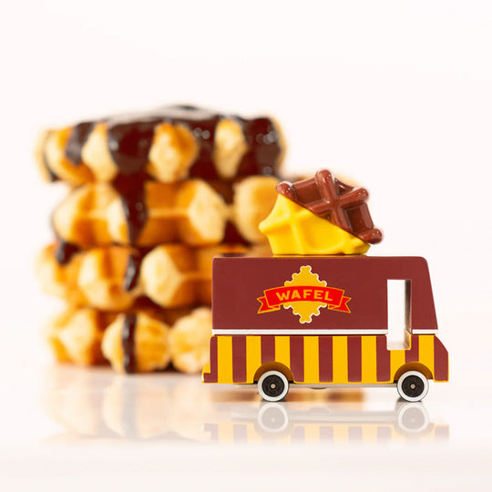 Lifestyle Image. This adorable wooden van is made of solid beechwood and features a bright yellow body with a chocolate-dipped waffle on the roof. It's the perfect size for little hands to grasp, and it's durable enough to withstand even the most vigorous play.