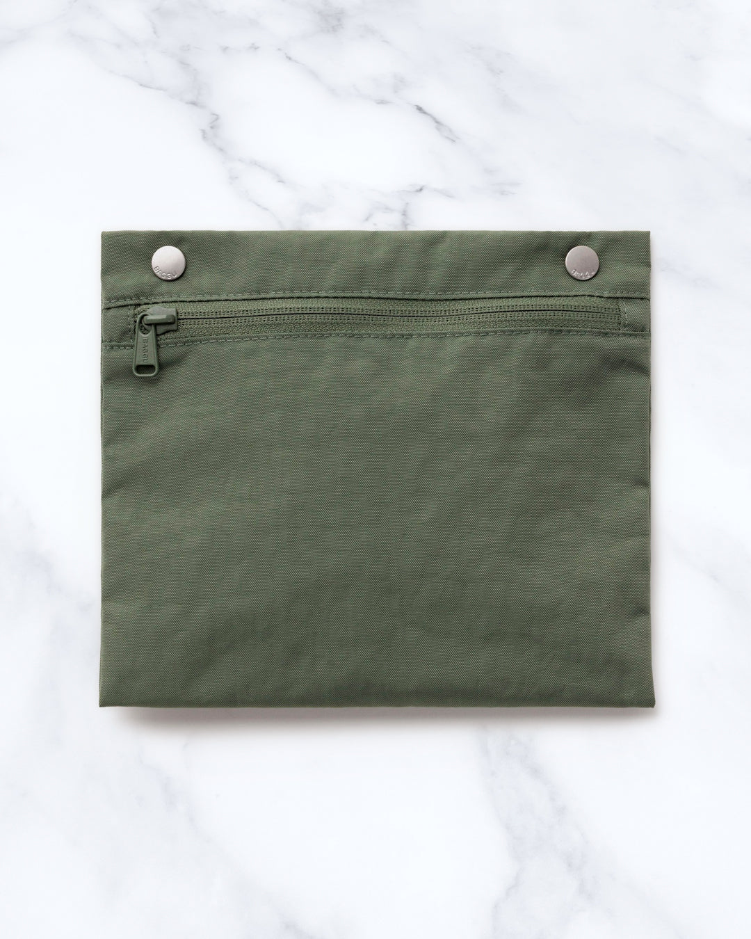 Made from recycled heavyweight nylon, it holds its shape without feeling rigid. The layout is considered: a zipped laptop sleeve sits to one side