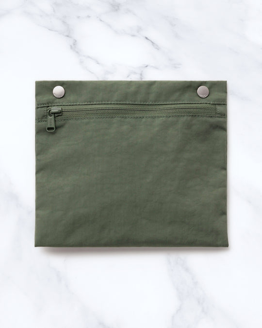 Made from recycled heavyweight nylon, it holds its shape without feeling rigid. The layout is considered: a zipped laptop sleeve sits to one side