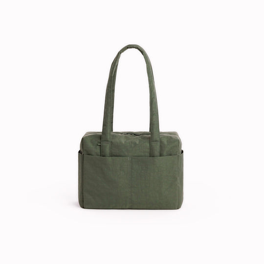 Made from recycled heavyweight nylon, it holds its shape without feeling rigid. The layout is considered: a zipped laptop sleeve sits to one side