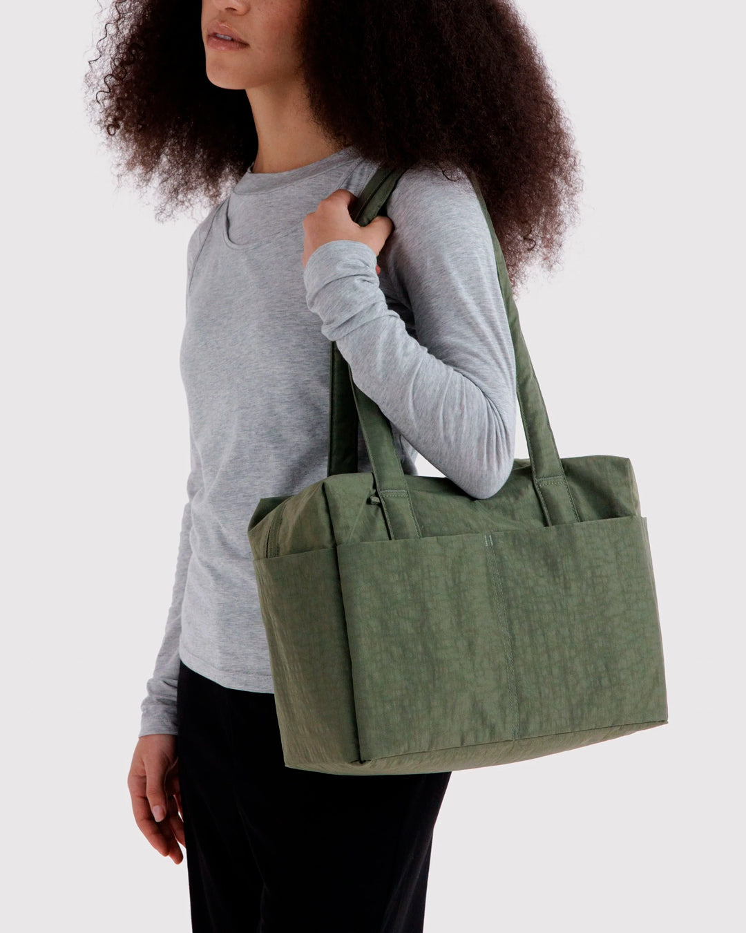 Made from recycled heavyweight nylon, it holds its shape without feeling rigid. The layout is considered: a zipped laptop sleeve sits to one side