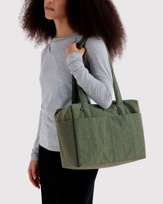 Made from recycled heavyweight nylon, it holds its shape without feeling rigid. The layout is considered: a zipped laptop sleeve sits to one side