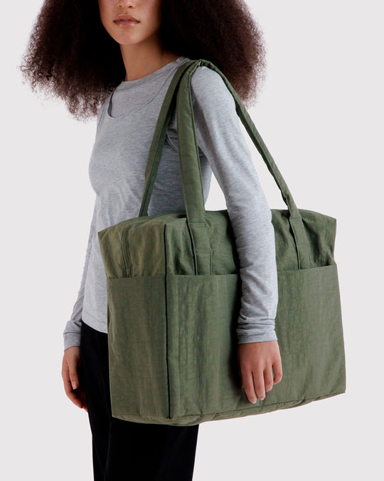 The BAGGU Cloud Carry-On is a spacious travel bag sized for overhead storage, with a trolley sleeve for easy attachment to your roller luggage. 