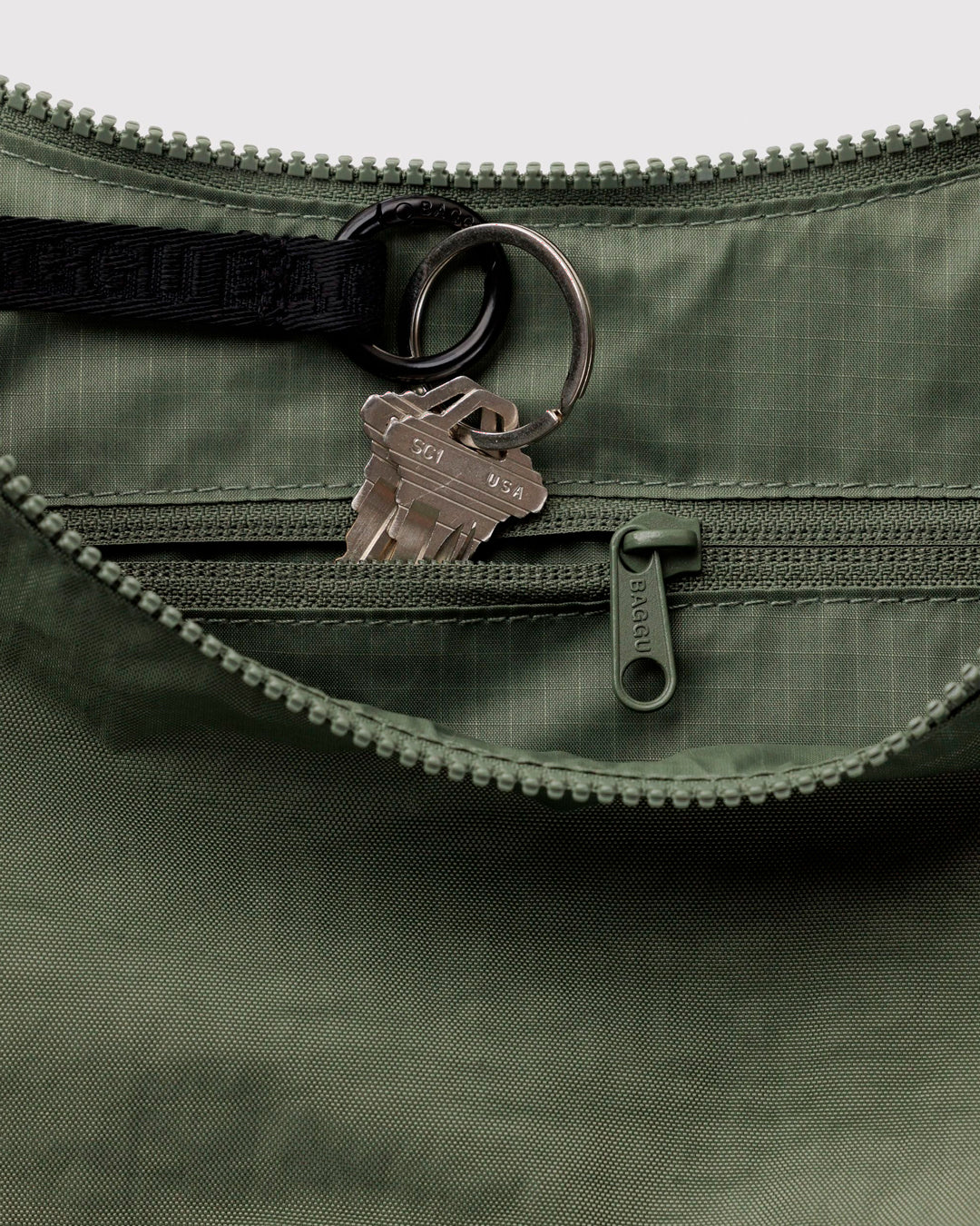 Made from recycled heavyweight nylon with a ripstop lining, it holds its form while staying lightweight. The strap adjusts to wear crossbody or over the shoulder, shifting the silhouette depending on how it’s carried.