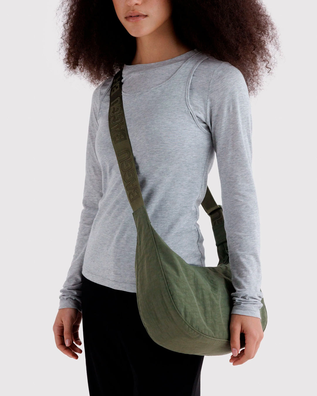 Made from recycled heavyweight nylon with a ripstop lining, it holds its form while staying lightweight. The strap adjusts to wear crossbody or over the shoulder, shifting the silhouette depending on how it’s carried.