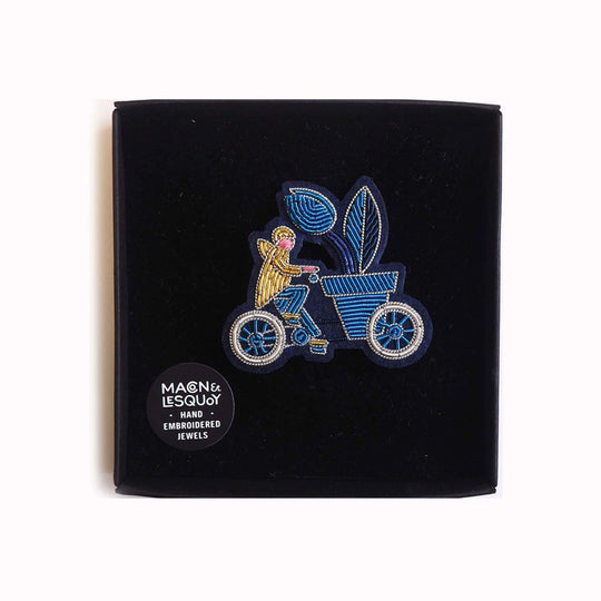Cargo Bike is a hand embroidered decorative brooch from Macon et Lesquoy in collaboration with Waldorf Astoria Amsterdam. A beautiful Amsterdam inspired lapel pin, featuring a cyclist transporting an oversized plant - a familiar sight on the streets of Amsterdam! In Box
