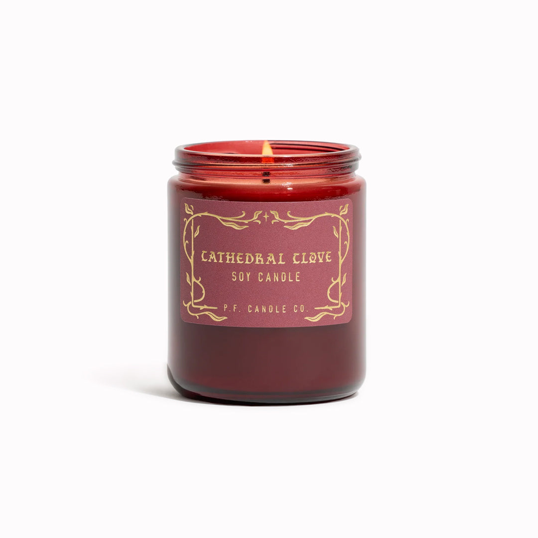 The Cathedral Clove candle from P.F. Candle Co. captures glowing fireplace embers, steam swirling off spiced tea, cool night air weaving through lace drapes.

