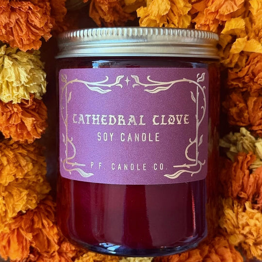 The Cathedral Clove candle from P.F. Candle Co. captures glowing fireplace embers, steam swirling off spiced tea, cool night air weaving through lace drapes.