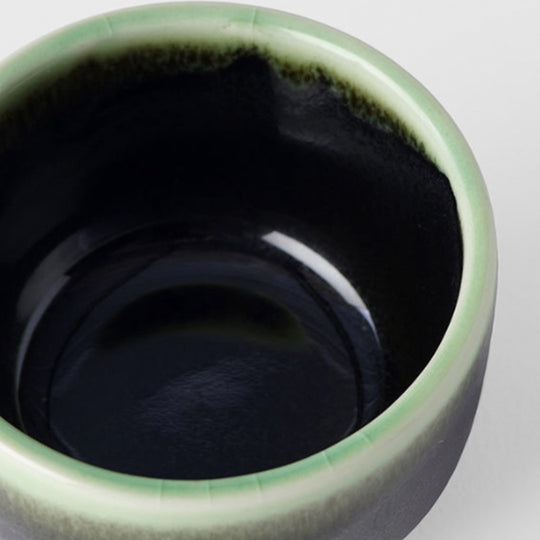 Black Green Sake Cup from Made in Japan. Working from a black base, the green is applied to the rim from above and allowed to drip down the cup to create an organic look. Detail Imahe