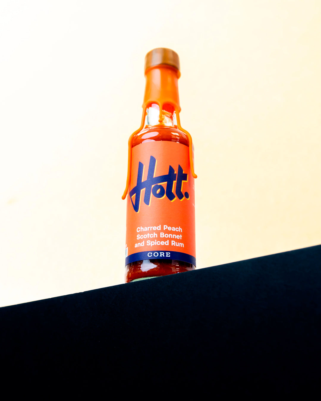This unique sauce boasts a distinctive flavour profile, combining the sweetness of charred peaches with the warmth of Scotch bonnets and the aromatic complexity of spiced rum, featuring notes of ginger, cinnamon, cloves, and vanilla.