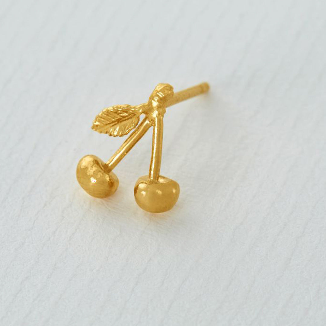 Detail of Gold Fruity Cherry Single stud earring from Alex Monroe's 'La Dolce Vita' collection. Inspired by long warm days in Italy, and the scents of summer fruits.