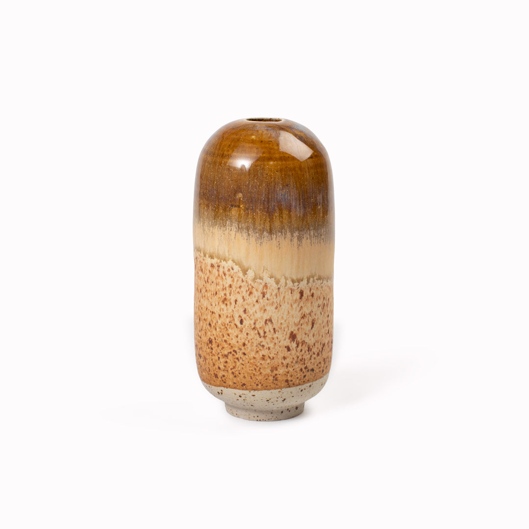 The Chocolate Fizz Mini Yuki Vase&nbsp;design is hand-thrown in watertight stoneware. Due to the rounded taper at the top of the vase, the glaze melts down the sides of the cylindrical vase mimicking melting ice.&nbsp;