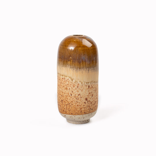 The Chocolate Fizz Mini Yuki Vase&nbsp;design is hand-thrown in watertight stoneware. Due to the rounded taper at the top of the vase, the glaze melts down the sides of the cylindrical vase mimicking melting ice.&nbsp;