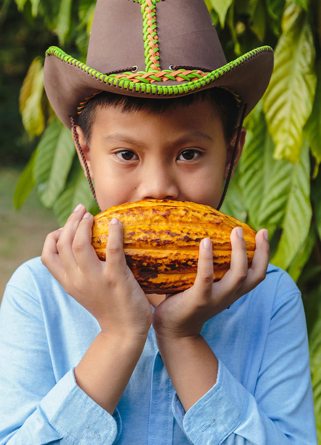 boy holding cocoa bean up
