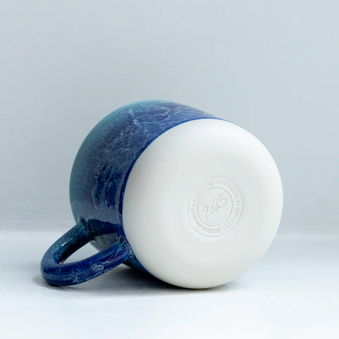 Mariana is a blue hued heavy glazed, Japanese inspired ceramic mug from Studio Arhoj. The Chug Mug features their trademark thick, hand poured coloured glaze which means that each mug is unique.