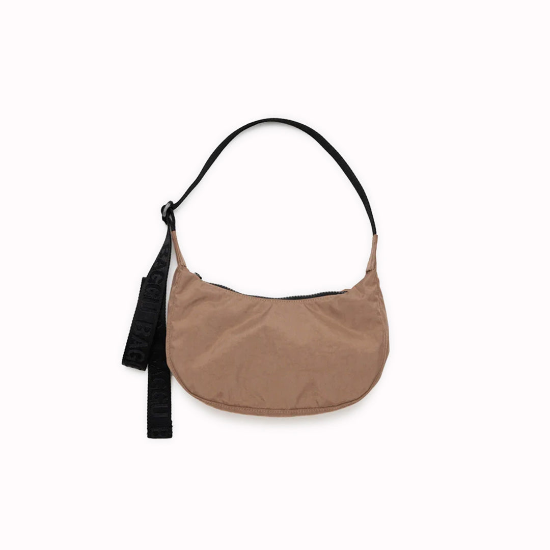 The Small Cocoa Crescent Bag from Baggu is a stylish and versatile accessory that can complement any outfit.
