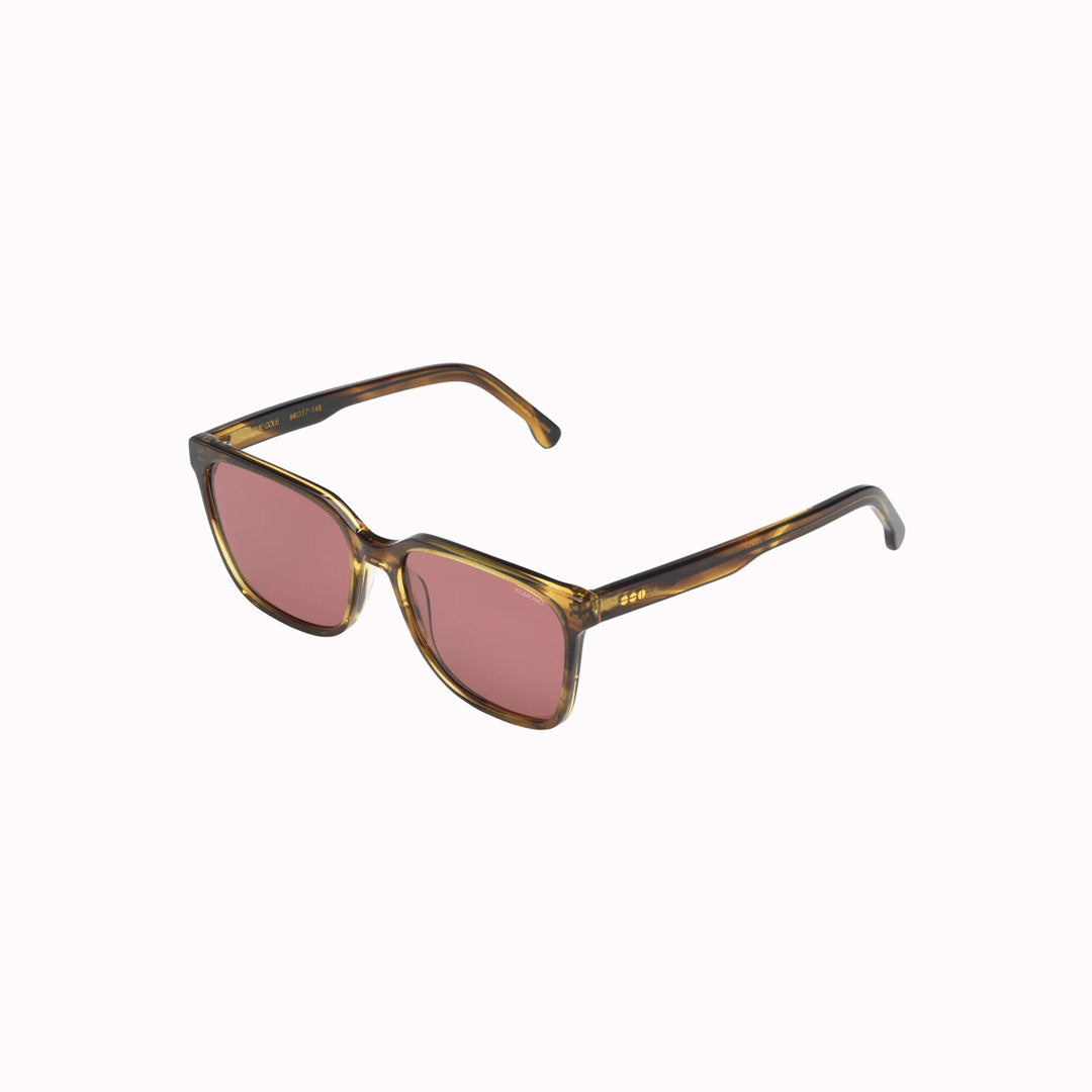 Side view. Strong lines, elegant and fine. The Cole sunglesses from Komono make sure to bring out your best features with their fine acetate frame. Desert Dust is a golden-brown frame colour, which looks really striking with the solid burgundy lenses. 