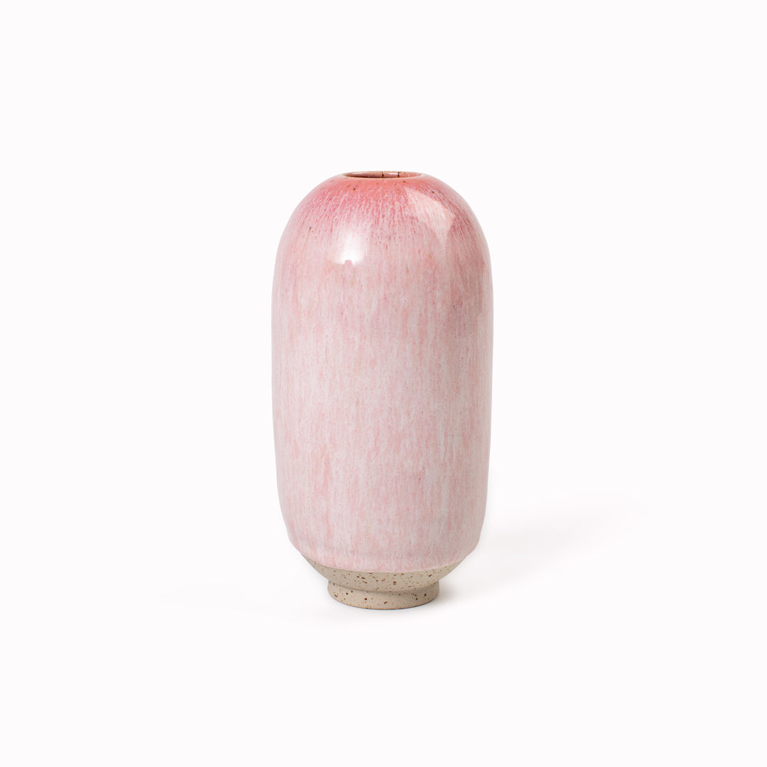 The Cream Cerise Mini Yuki Vase design is hand-thrown in watertight stoneware. Due to the rounded taper at the top of the vase, the glaze melts down the sides of the cylindrical vase mimicking melting ice.&nbsp;