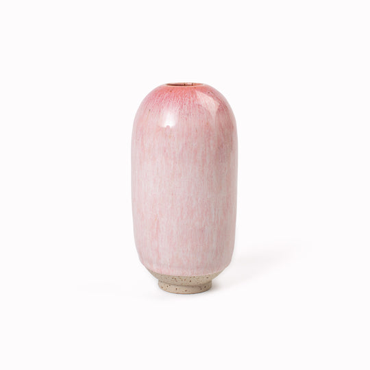 The Cream Cerise Mini Yuki Vase design is hand-thrown in watertight stoneware. Due to the rounded taper at the top of the vase, the glaze melts down the sides of the cylindrical vase mimicking melting ice.&nbsp;