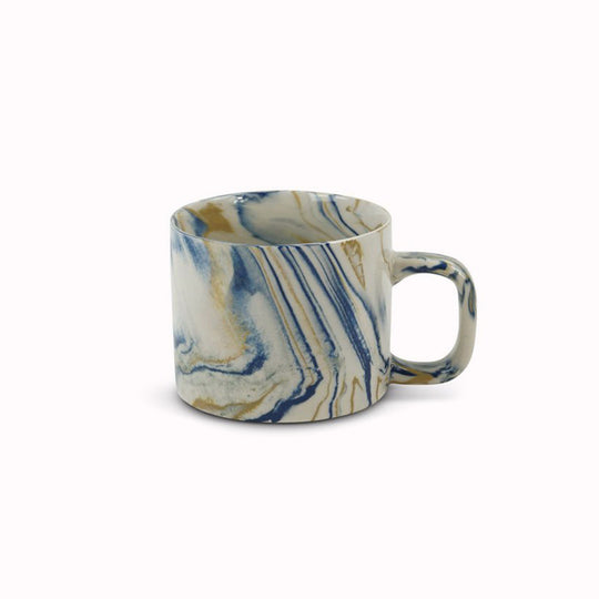 Blue and mustard marbled gloss glaze mug from Dutch company Kinta, who produce contemporary ceramics and homeware. The stoneware mug has a striking marbled effect glaze with blue and mustard colouring. The glaze on the outside and on the interior is glossy and it holds 200ml
