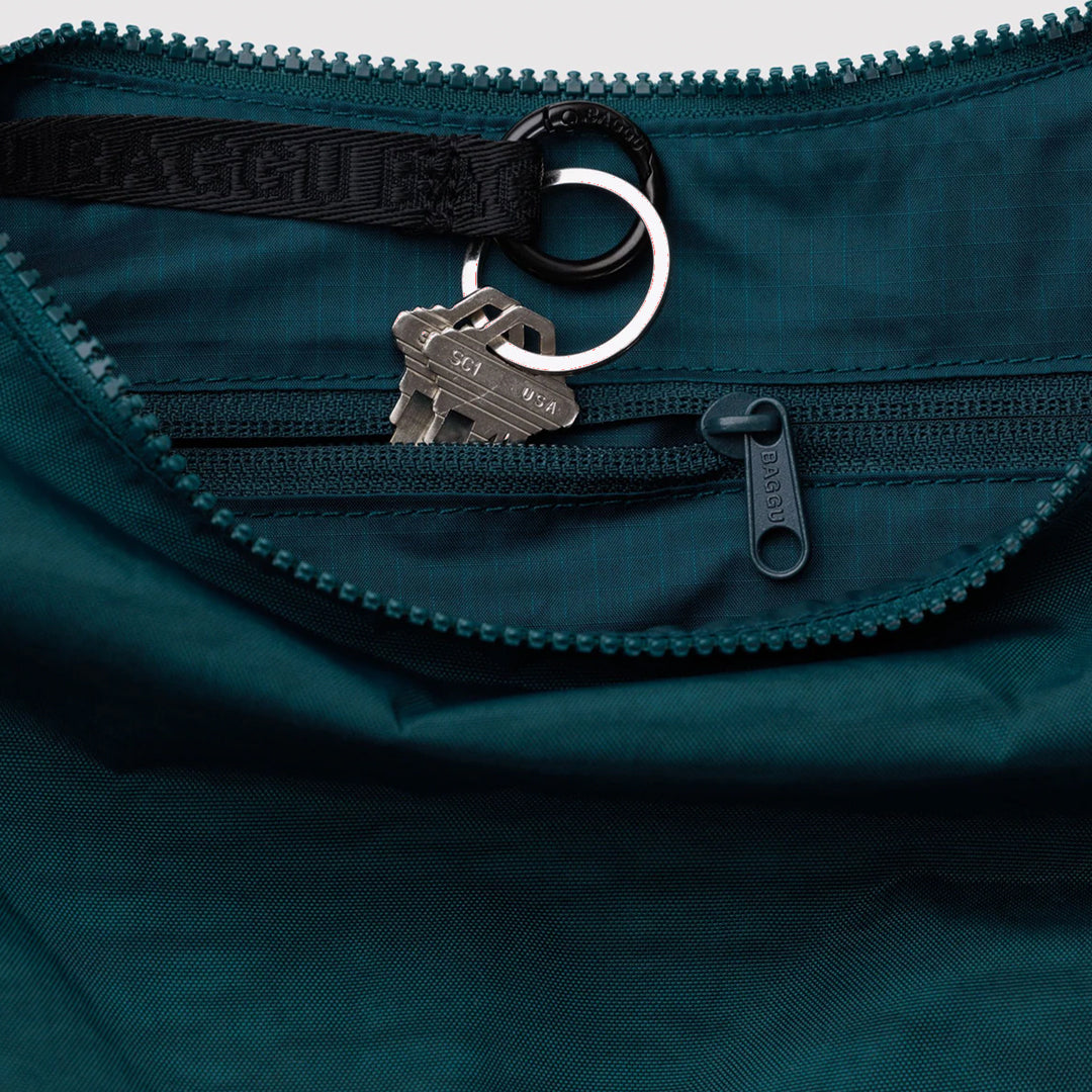 The Medium Crescent Bag in Deep Sea from Baggu is a stylish and versatile accessory that can complement any outfit.