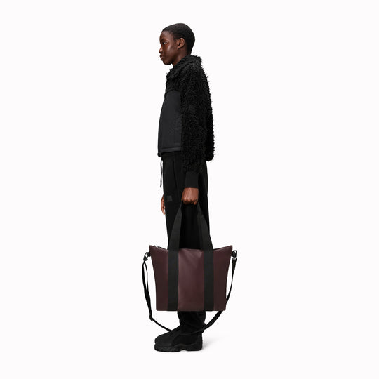 Rains' Tote Bag Mini W3 is a waterproof tote bag&nbsp;and an ideal companion for shopping trips&nbsp;as well as commuting to the office. Functional design elements include a full length coated zip for added water protection