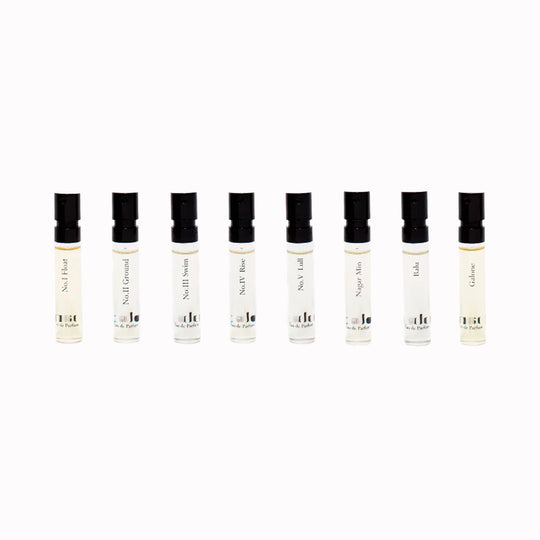 Row of small perfume bottles with black caps on a white background from Gabar Fragrance Discovery Set
