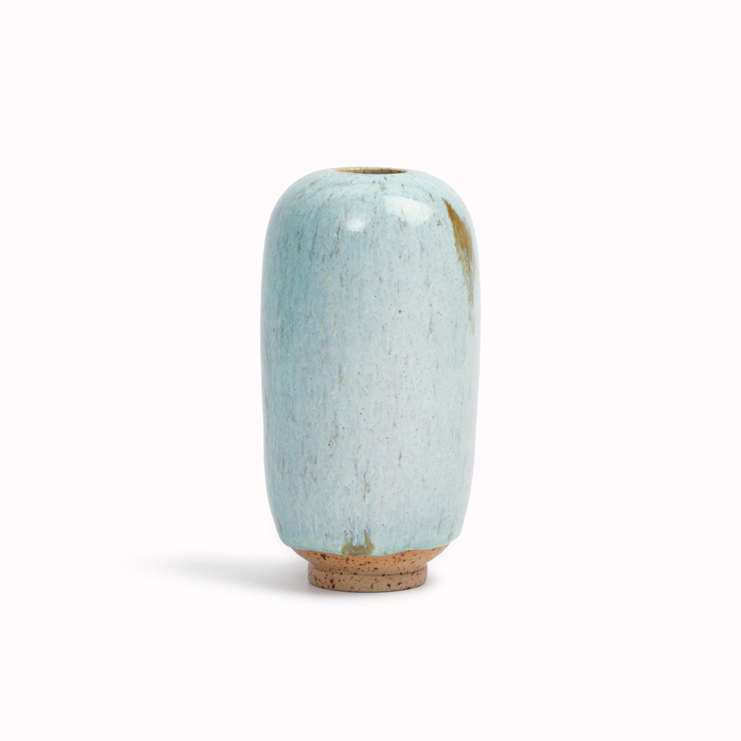 The Dusty Blue multi-shaded blue design is hand-thrown in watertight stoneware. Due to the rounded taper at the top of the vase, the glaze melts down the sides of the cylindrical vase mimicking melting ice.