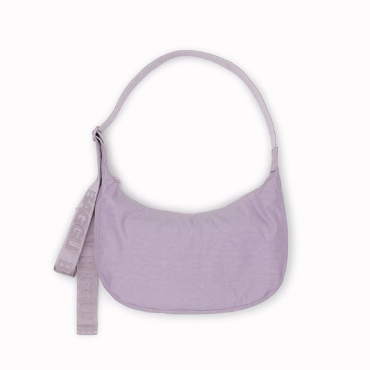 The Medium Crescent Bag in Dusty Pink from Baggu is a stylish and versatile accessory that can complement any outfit. It is made of durable nylon and features a zippered main compartment, an interior slip pocket, and an adjustable shoulder strap.