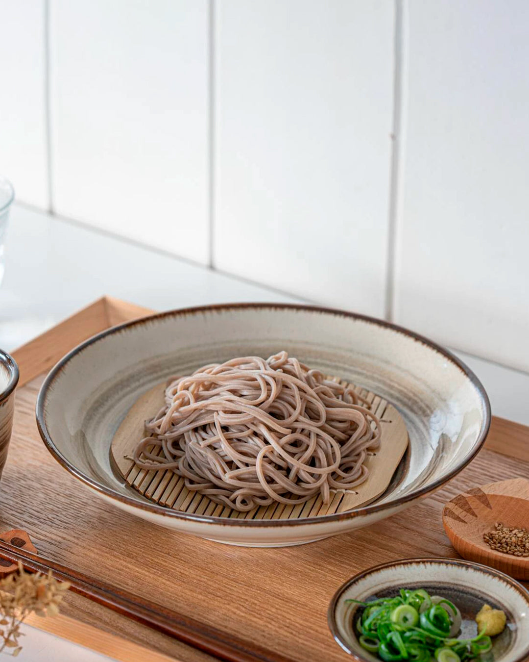 Shallow noodle bowl with irregular earthy toned swirl pattern on a cream glazed base. Diameter 23cm and height approx 5cm.