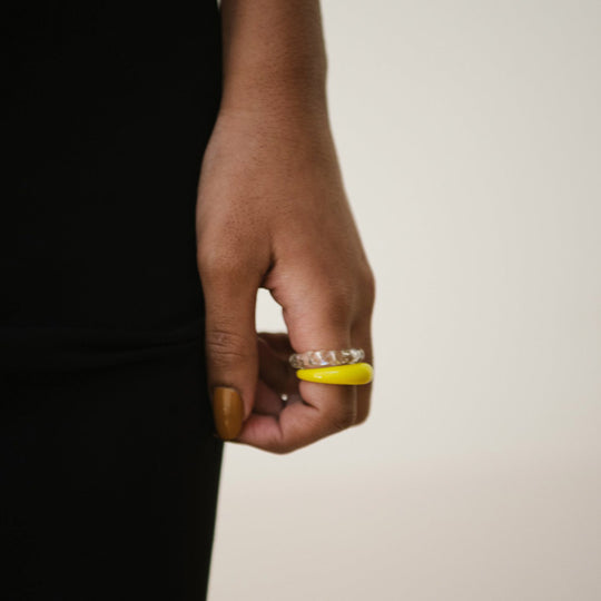 As worn by model, Flora is a bright yellow handblown glass ring, handmade by Eyland Jewellery, who produce contemporary and colourful pieces of costume jewellery.