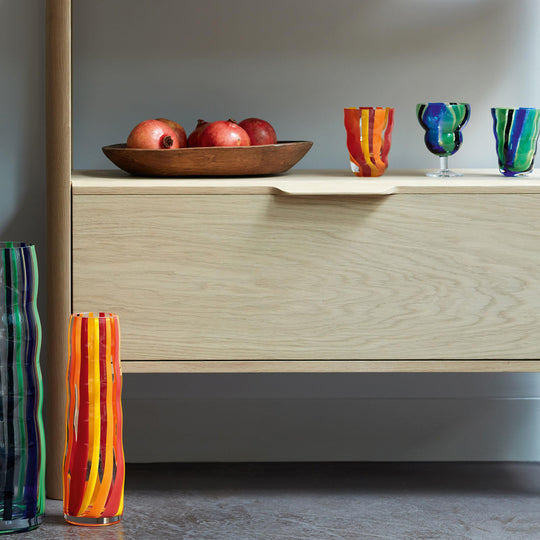 Part of the LSA International Folk Collection, this tall and slender glass Folk Vase has been hand painted with Orange, Red and Yellow stripes for bright and bold impact.&nbsp;