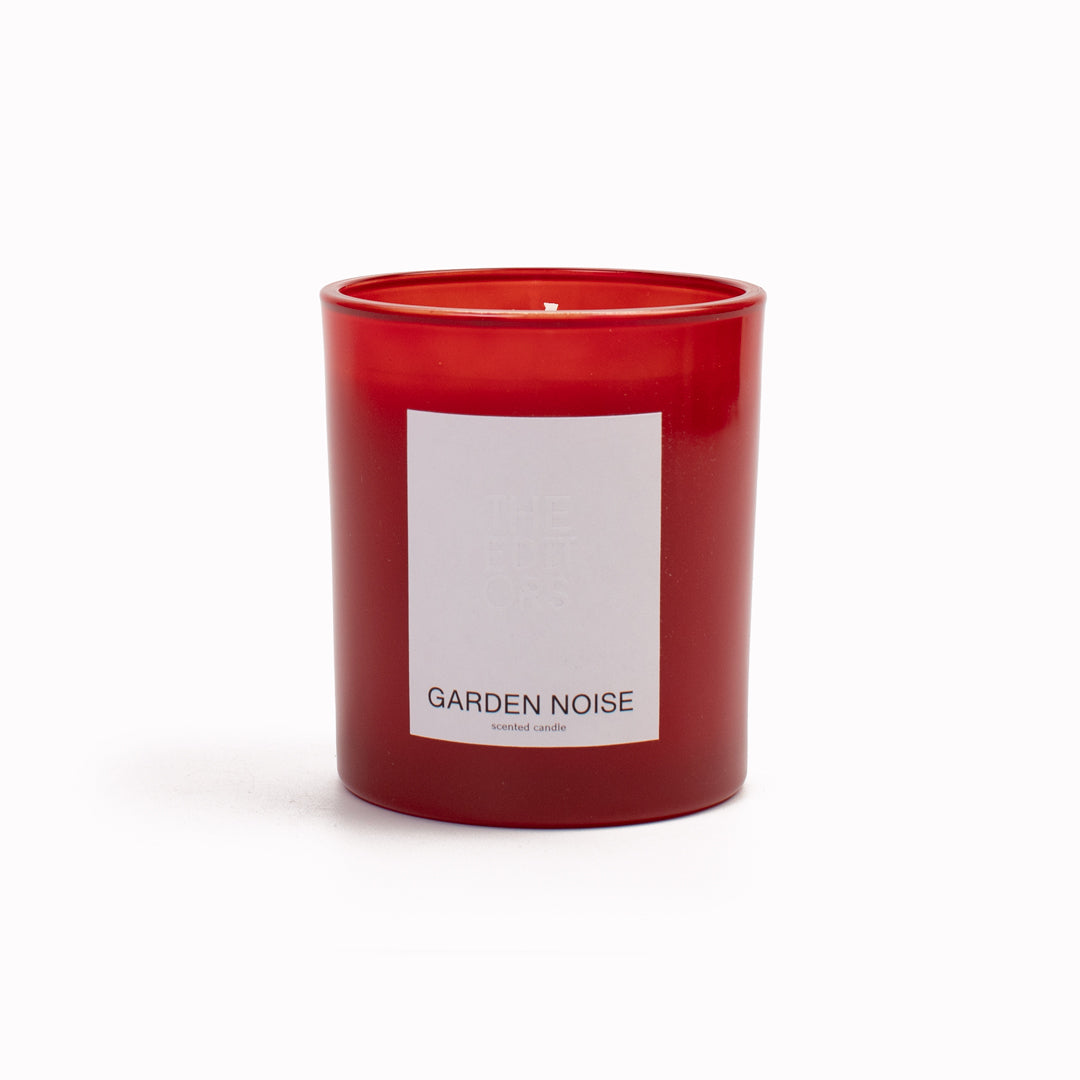 The Editors NYC Garden Noise Candle red painted glass vessel on white