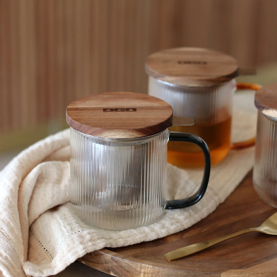 Tea for one in a borosilicate glass teapot mug with graphite grey handle, by French brand Ogo Living. Topped with a wooden lid to keep your tea warm while it brews.