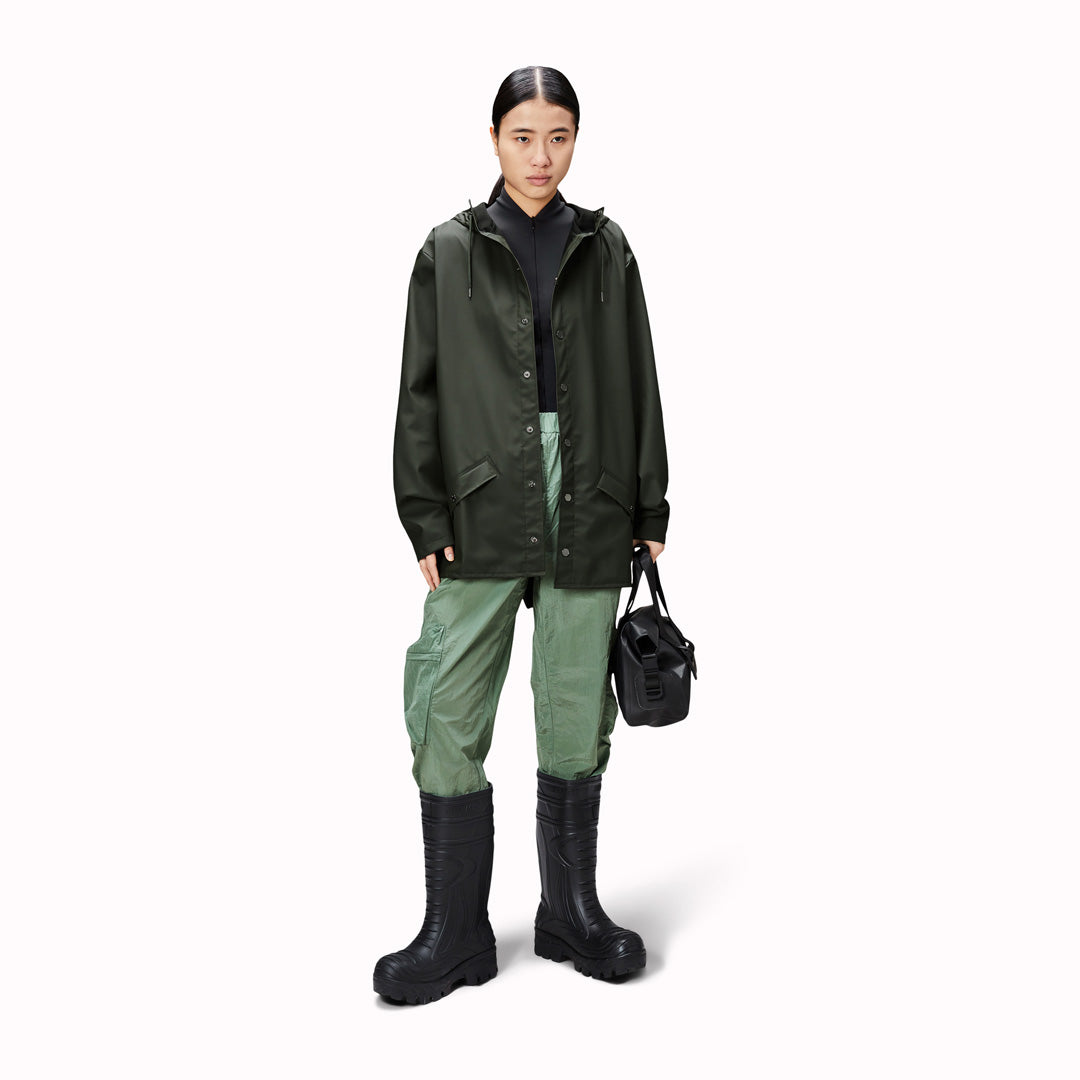 Contemporary unisex rain jacket from Danish Outerwear and Lifestyle company Rains. This green jacket is characterized by a minimal silhouette with high functionality.