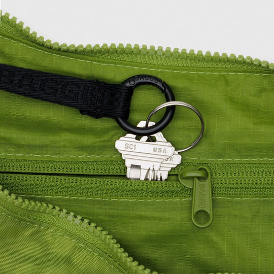The Medium Crescent Bag in Green Juice from Baggu is a stylish and versatile accessory that can complement any outfit. It is made of durable nylon and features a zippered main compartment, an interior slip pocket, and an adjustable shoulder strap.