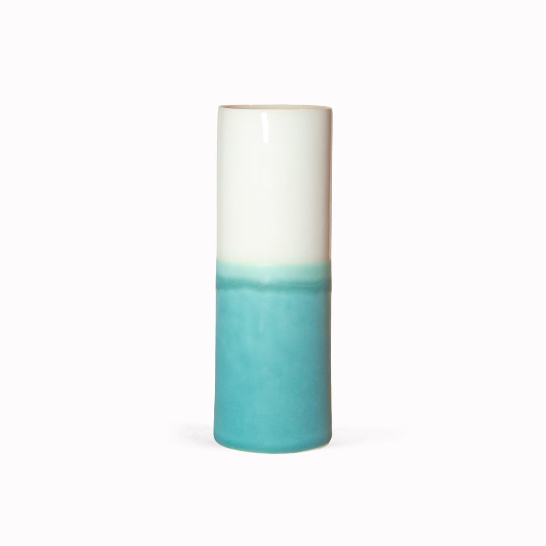 Porcelain cylinder vase from London based SGW Lab, glazed in shades of turquoise on a white base.