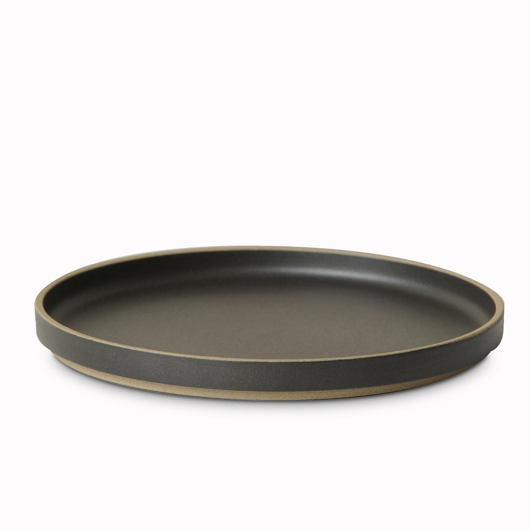 Matt black porcelain plate by Hasami Porcelain is a stackable serving plate with high rimmed edge, suitable for use as a dinner plate or a serving plate for sharing dishes or sides to accompany a meal