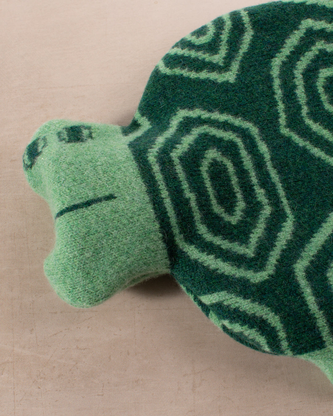 Made in Scotland from 100% lambswool, the Tortoise Hot Water Bottle is a soft and cuddly companion by Donna Wilson. 