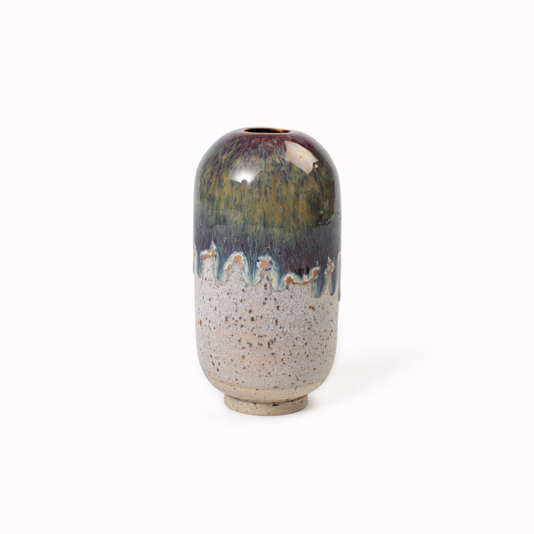 The Iron Storm Mini Yuki Vase design is hand-thrown in watertight stoneware. Due to the rounded taper at the top of the vase, the glaze melts down the sides of the cylindrical vase mimicking melting ice.&nbsp;