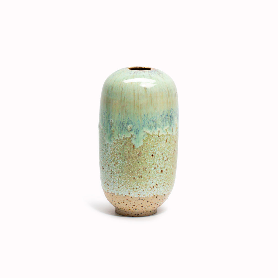 The Jade Fade, green melted design is hand-thrown in watertight stoneware. Due to the rounded taper at the top of the vase, the glaze melts down the sides of the cylindrical vase mimicking melting ice.